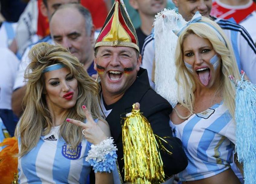 Due aggressive tifose argentine insieme ad un contentissimo tifoso tedesco. Reuters